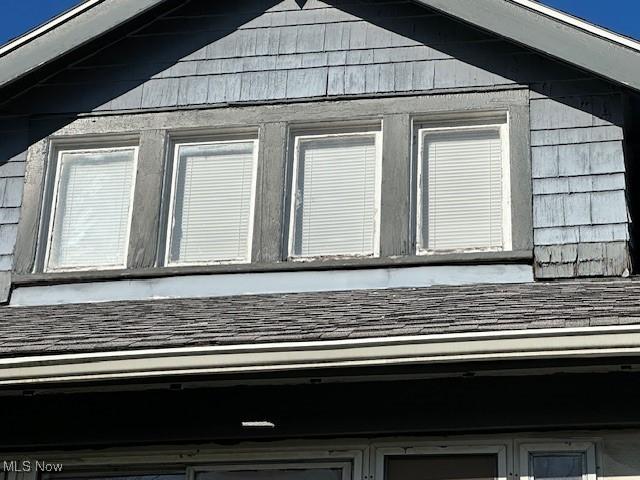 exterior details featuring roof with shingles