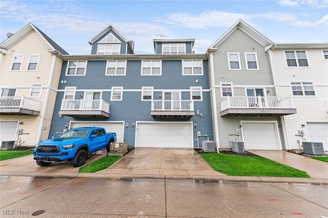 multi unit property featuring a garage, central AC, and driveway