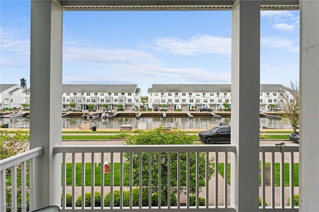 balcony with a residential view and a water view