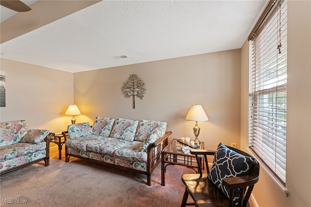 carpeted living room with visible vents and a textured ceiling