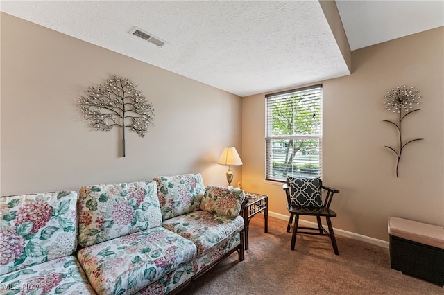 carpeted living area featuring a textured ceiling, visible vents, and baseboards