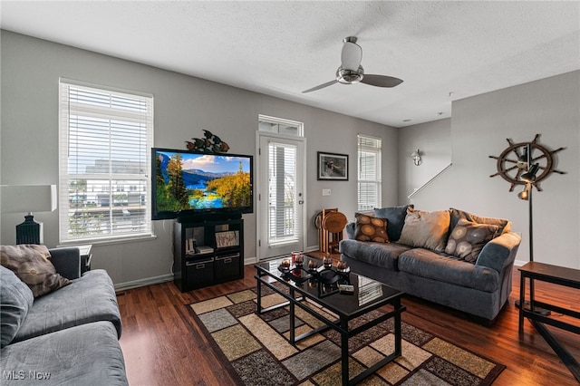 living room with a ceiling fan, a textured ceiling, baseboards, and wood finished floors