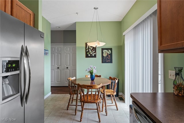 dining space featuring light tile patterned floors and baseboards