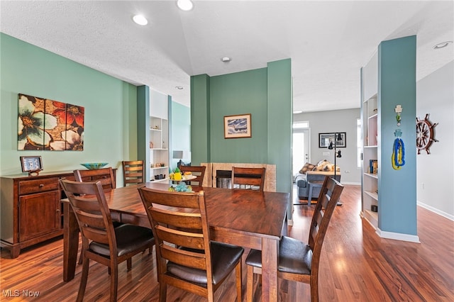 dining area with a textured ceiling, wood finished floors, and baseboards