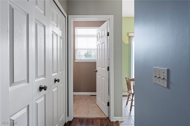 corridor featuring tile patterned flooring and baseboards