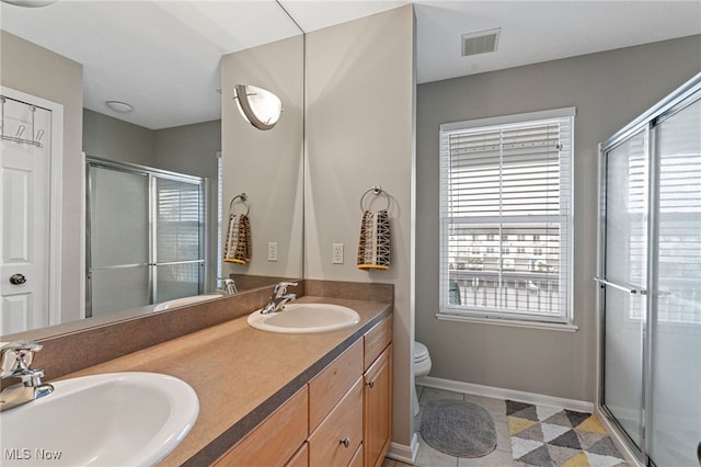 bathroom with a wealth of natural light, visible vents, and a sink