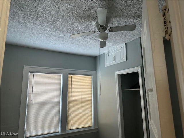 room details with a ceiling fan and a textured ceiling