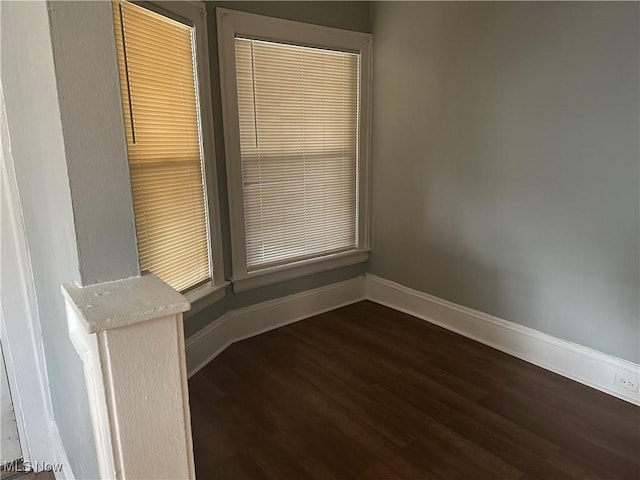 unfurnished room featuring dark wood-style flooring and baseboards