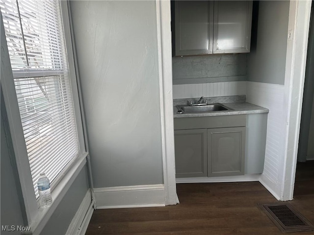 interior space featuring visible vents, dark wood-style floors, gray cabinets, light countertops, and a sink