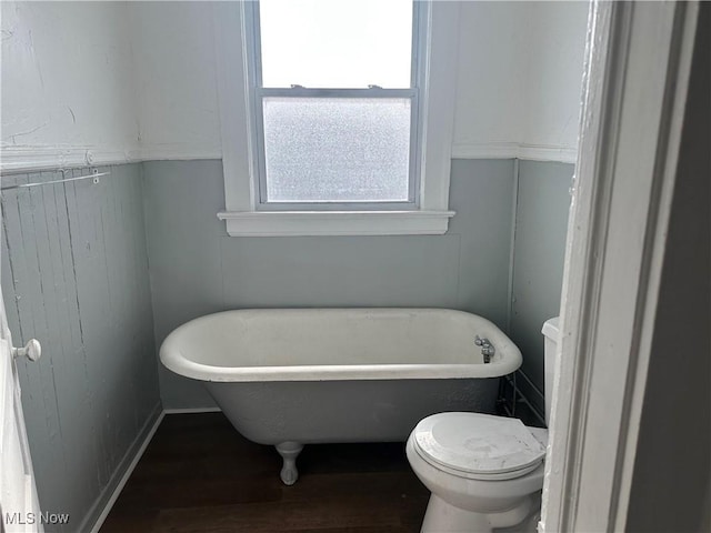 full bathroom featuring toilet and a soaking tub