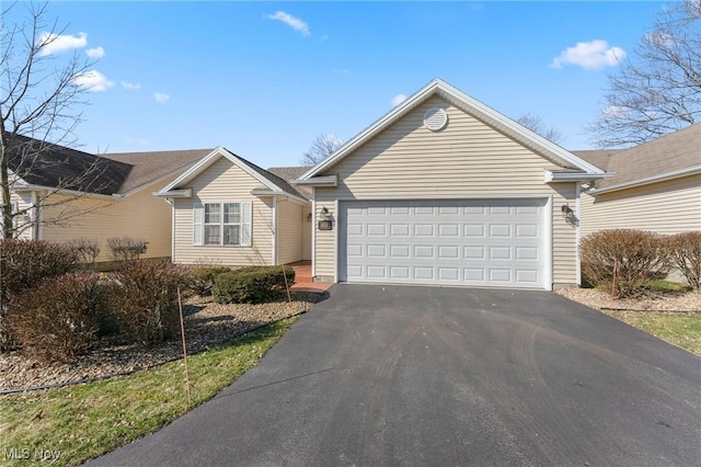 ranch-style house with aphalt driveway and a garage