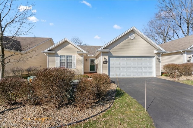 single story home featuring aphalt driveway and an attached garage