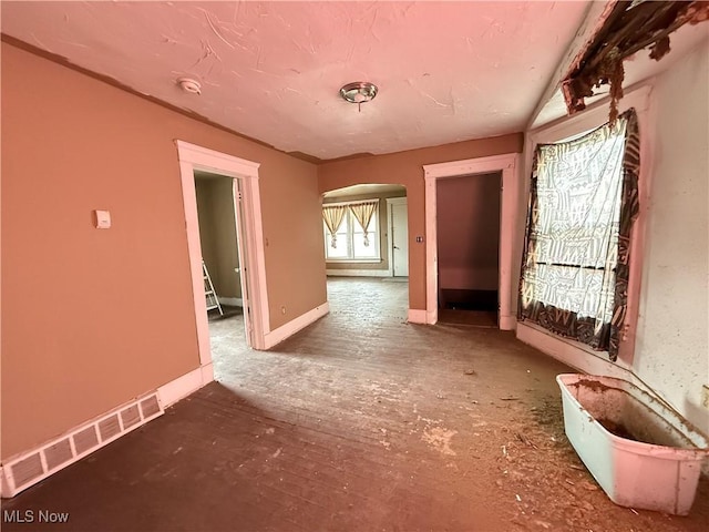 unfurnished room featuring baseboards and visible vents