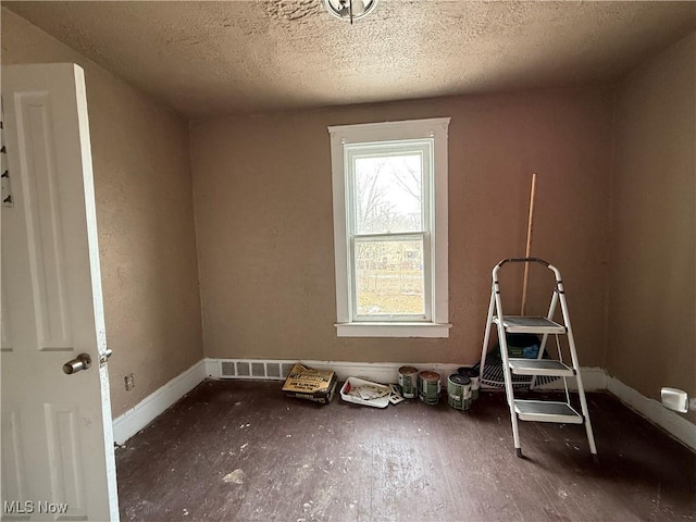 additional living space featuring baseboards and a textured ceiling