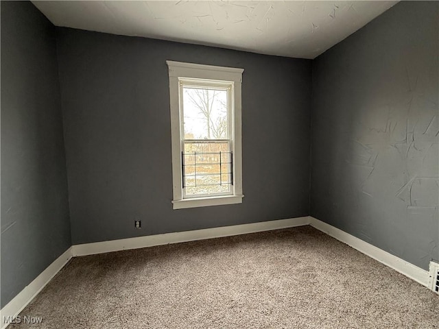 spare room with baseboards and carpet flooring