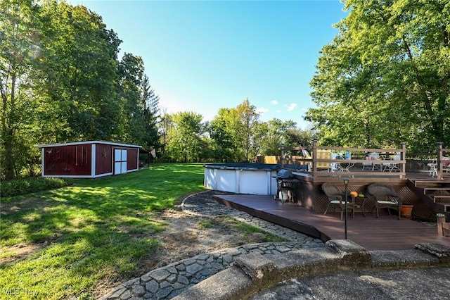 view of yard featuring an outdoor structure, a wooden deck, and a covered pool