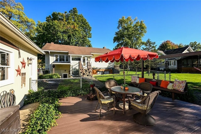 deck featuring outdoor dining space, fence, and a yard