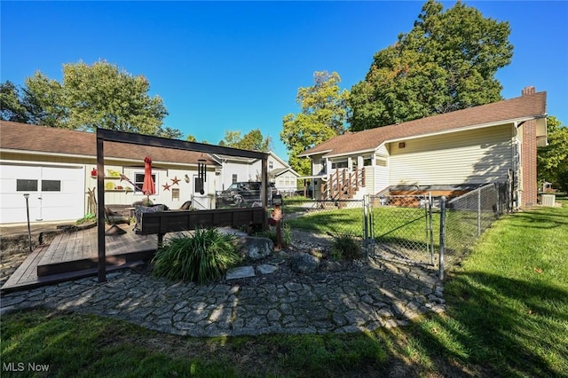 rear view of house featuring a gate, a lawn, a chimney, and fence