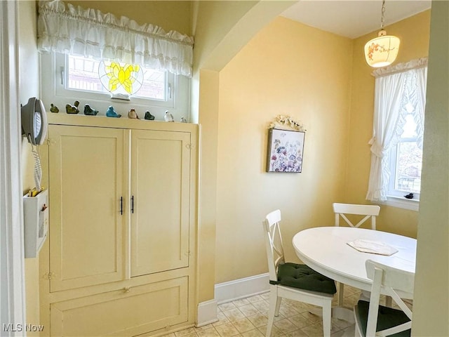 dining area with light tile patterned floors and baseboards