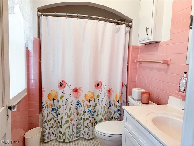 full bathroom featuring toilet, curtained shower, tile walls, and vanity