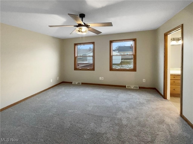 unfurnished bedroom with carpet floors, visible vents, ensuite bath, and baseboards