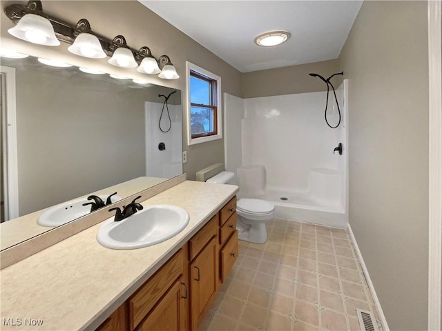 bathroom featuring toilet, vanity, walk in shower, and visible vents