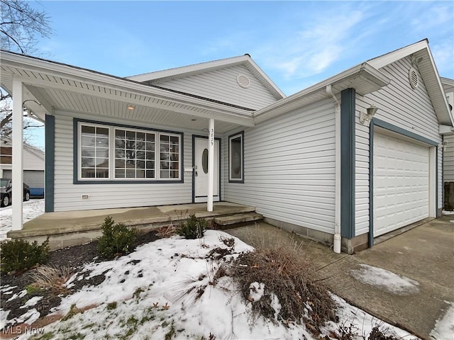 single story home featuring a garage, covered porch, and driveway