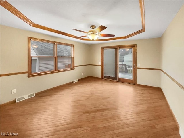 empty room with light wood-style floors, visible vents, and a ceiling fan