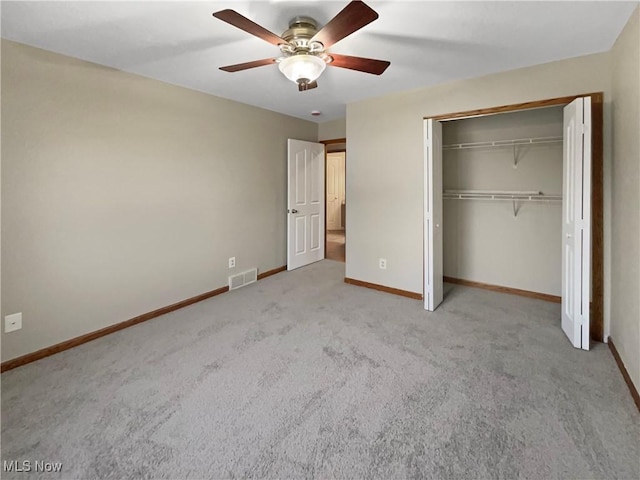 unfurnished bedroom featuring carpet, a closet, visible vents, ceiling fan, and baseboards