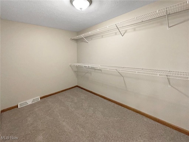 walk in closet with carpet floors and visible vents