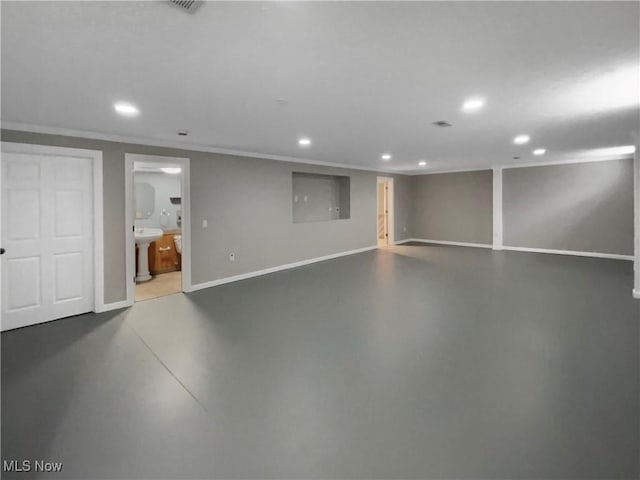 finished below grade area with baseboards, crown molding, a sink, and recessed lighting