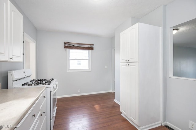 11915 Franklin Blvd, Lakewood, OH 44107 - kitchen featuring dark wood finished floors, white gas stove, light countertops, white cabinets, and baseboards