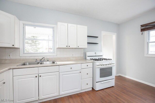 11915 Franklin Blvd, Lakewood, OH 44107 - kitchen with white gas range, dark wood-style flooring, backsplash, and a sink