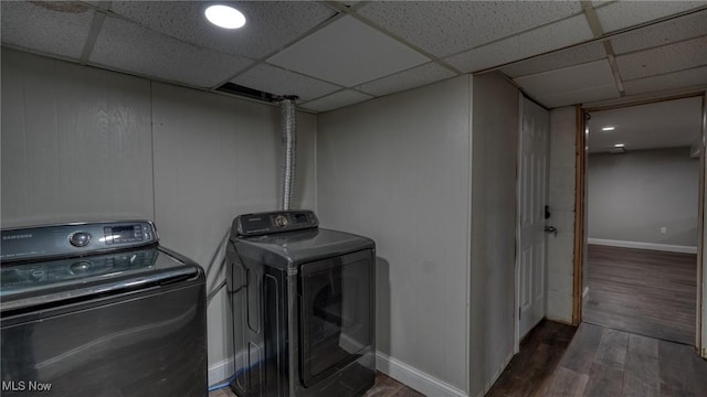 clothes washing area featuring baseboards, wood finished floors, and independent washer and dryer