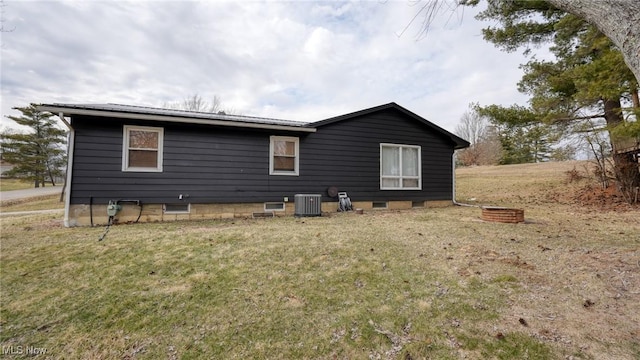 view of home's exterior with central AC unit and a lawn