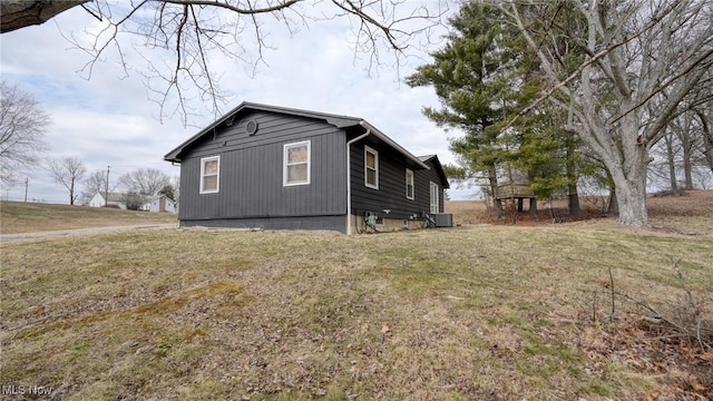 view of property exterior with a yard and central air condition unit