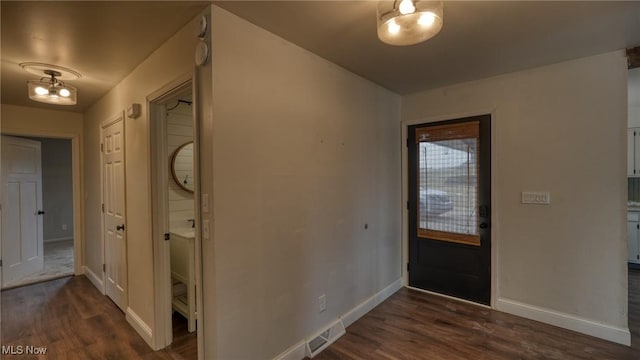 entrance foyer featuring dark wood-style floors, visible vents, and baseboards