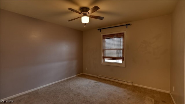 carpeted spare room with a baseboard radiator, a ceiling fan, and baseboards