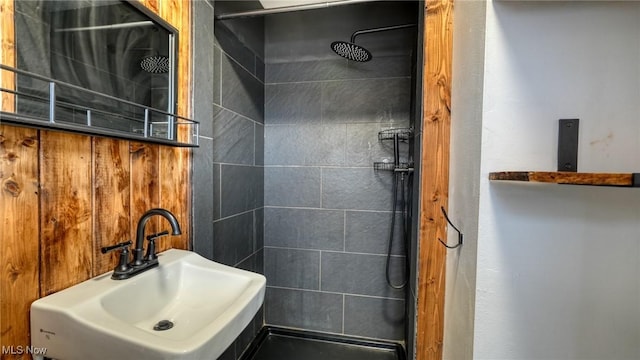 full bath featuring tiled shower and a sink