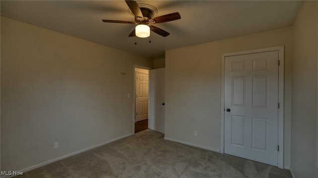 unfurnished bedroom with carpet floors, baseboards, and a ceiling fan