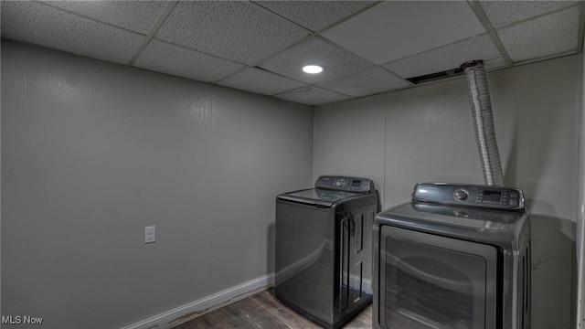 laundry room with laundry area, separate washer and dryer, wood finished floors, and baseboards