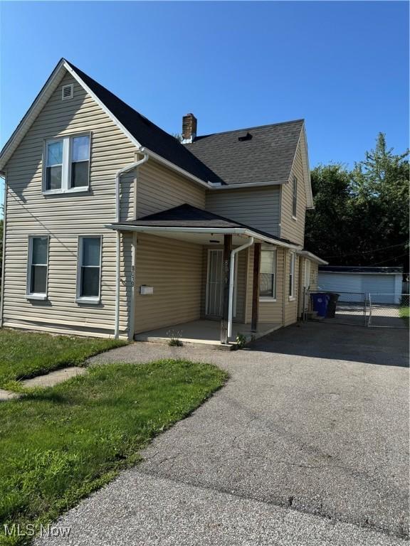 view of side of property featuring driveway and a chimney