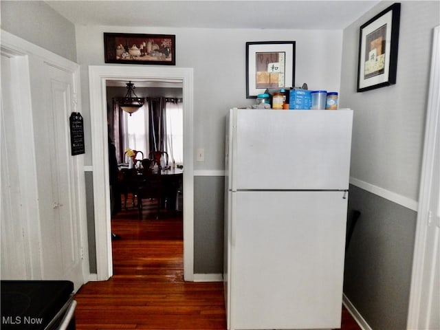 kitchen with stainless steel electric range, wood finished floors, freestanding refrigerator, and baseboards