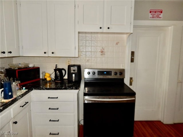 kitchen with electric range oven, tasteful backsplash, and white cabinetry