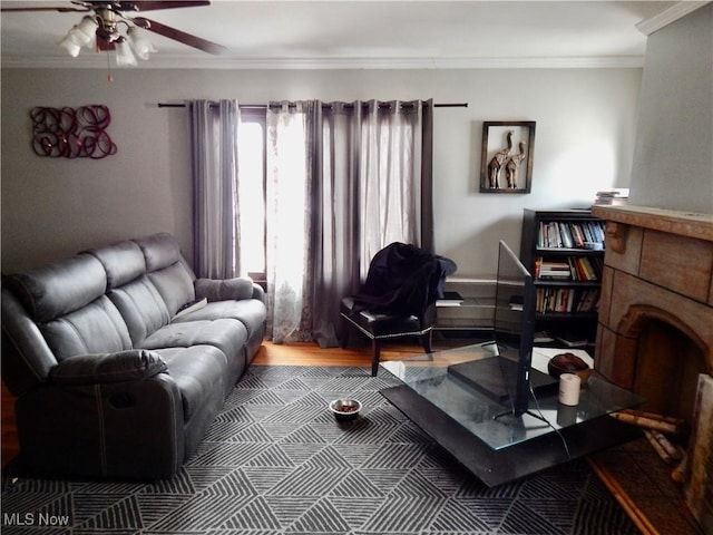 living area with ceiling fan, ornamental molding, and a fireplace