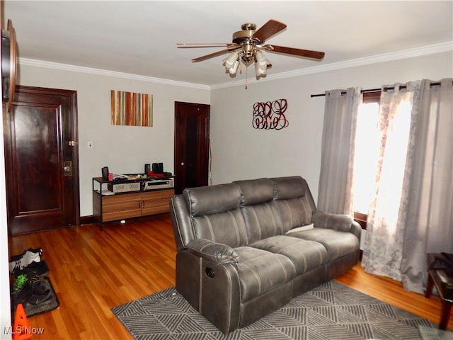 living area featuring ornamental molding, wood finished floors, and a ceiling fan