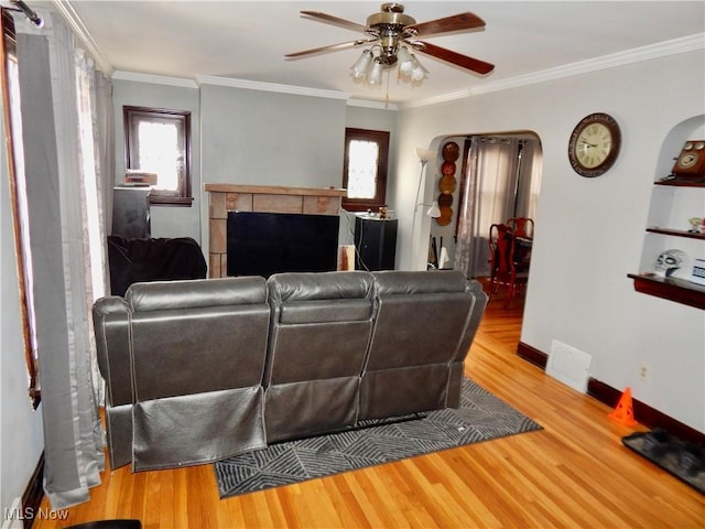 living area featuring ornamental molding, plenty of natural light, and wood finished floors