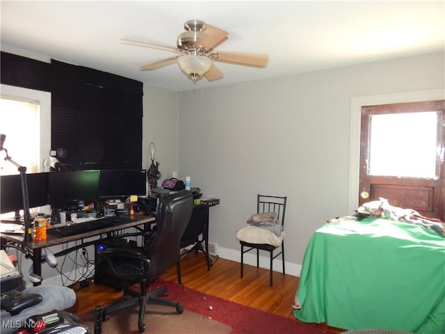 office area with plenty of natural light, baseboards, ceiling fan, and wood finished floors