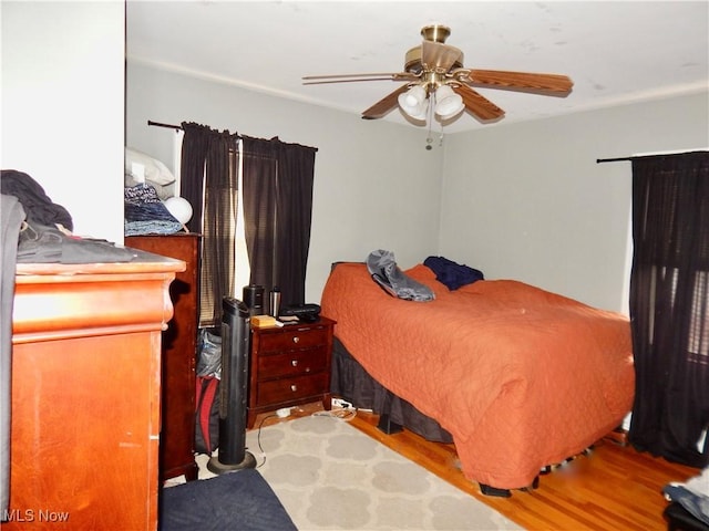 bedroom with a ceiling fan and wood finished floors