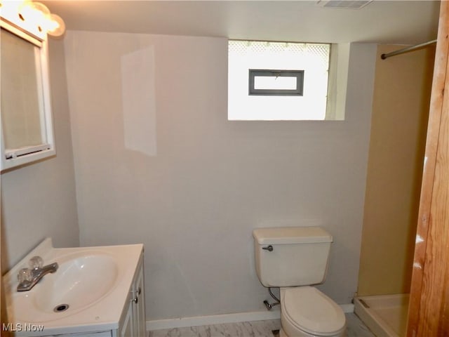 full bath featuring toilet, baseboards, walk in shower, and vanity